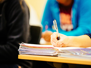 A closeup of a student's hand writing something in a notebook