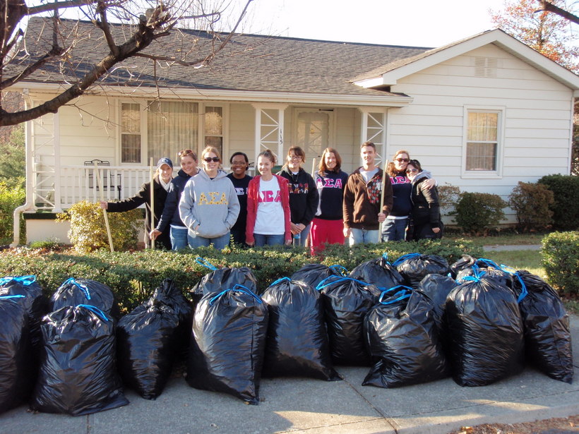 Students posing in front of multiple bags of trash