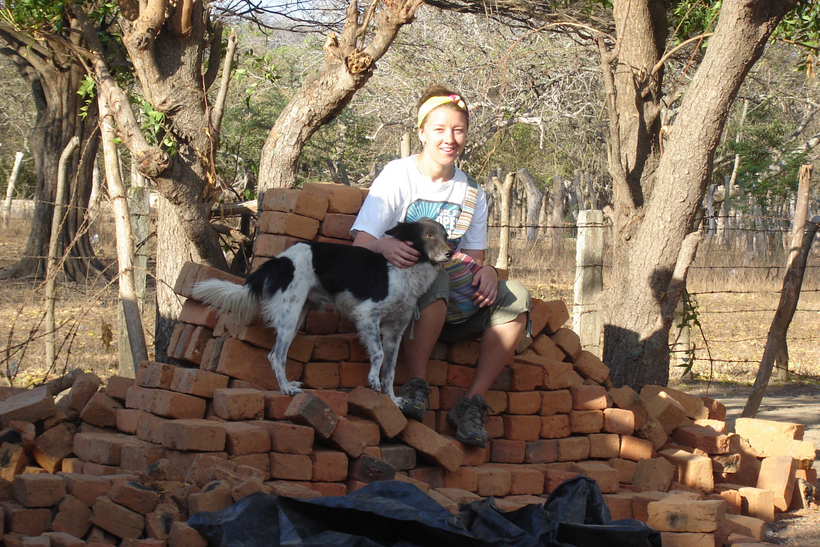 Student with a dog sitting on top of a pile of bricks