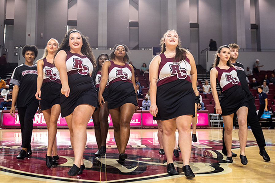  A group of dancers in Roanoke uniforms perform in the middle of the basketball arena.