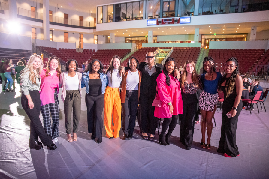 A group of young men and women pose together 