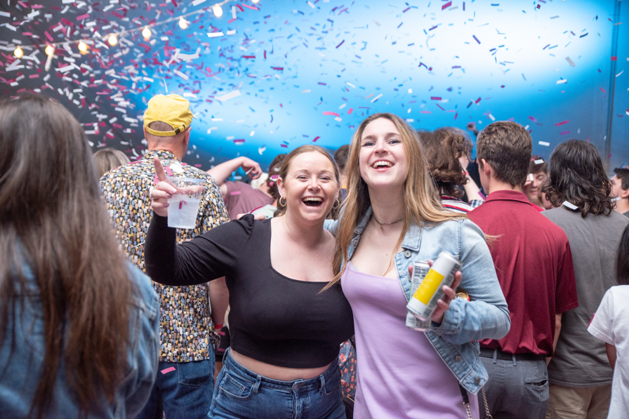 women celebrate on the dance floor as the air is filled with confetti