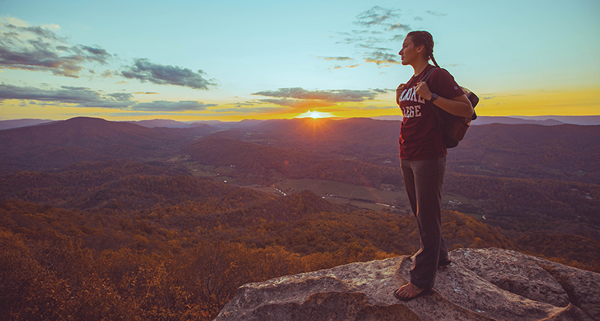 Student at the top of a mountain