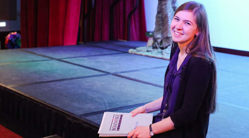 erin keating with a script while sitting on a stage