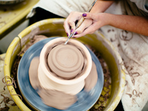 student working on pottery wheel