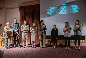 Charissa with professor and others standing in front of a screen