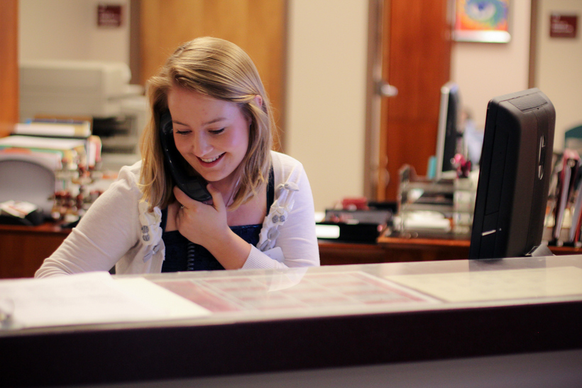Student working at a desk and answering the phone