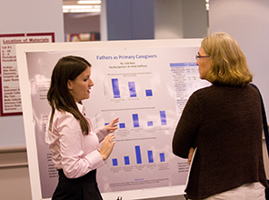 Photo of Julie Bass discussing research with a student