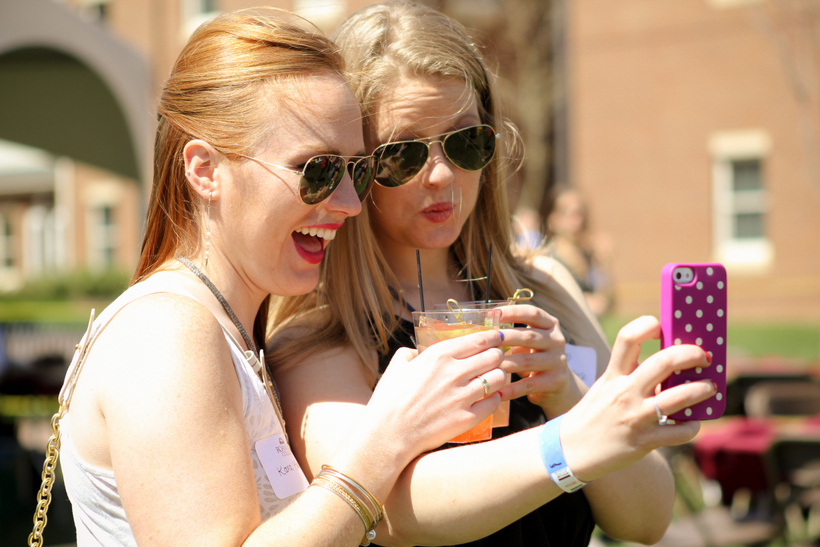 Two alumni take a selfie with their coffee.