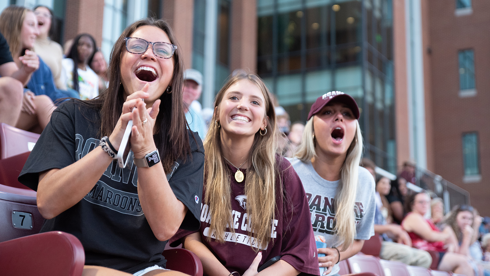 three women cheer on Roanoke at a game