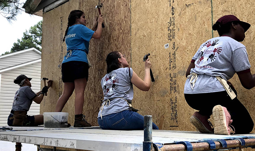 Students building a house on an alternative fall break trip