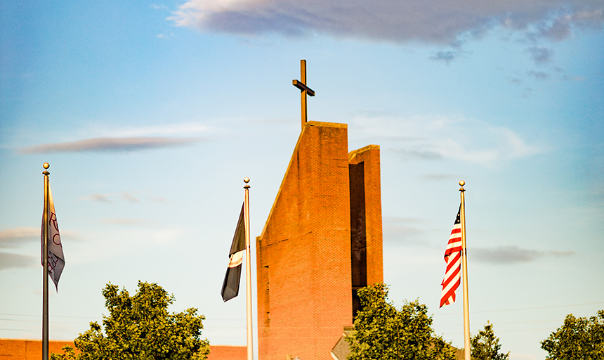 Chapel cross with flags in foreground