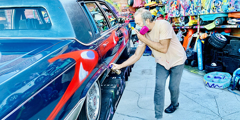 Kenny Scharf spray paints art on to car