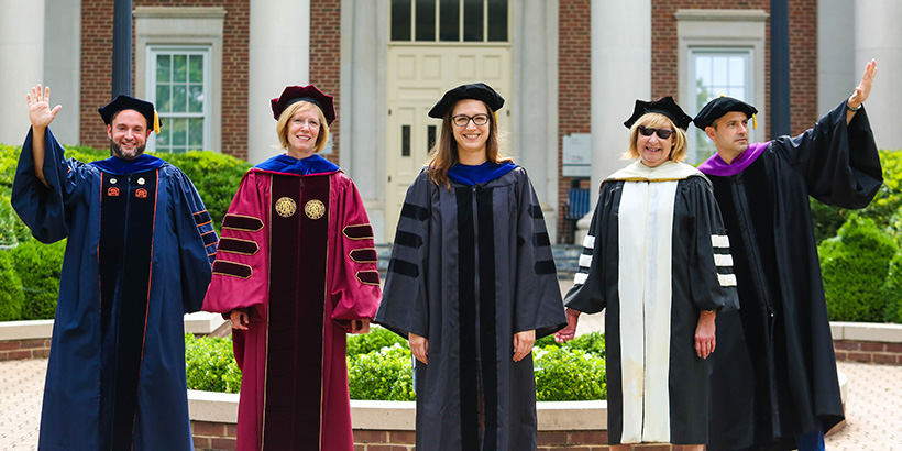 Five professors in academic robes and caps