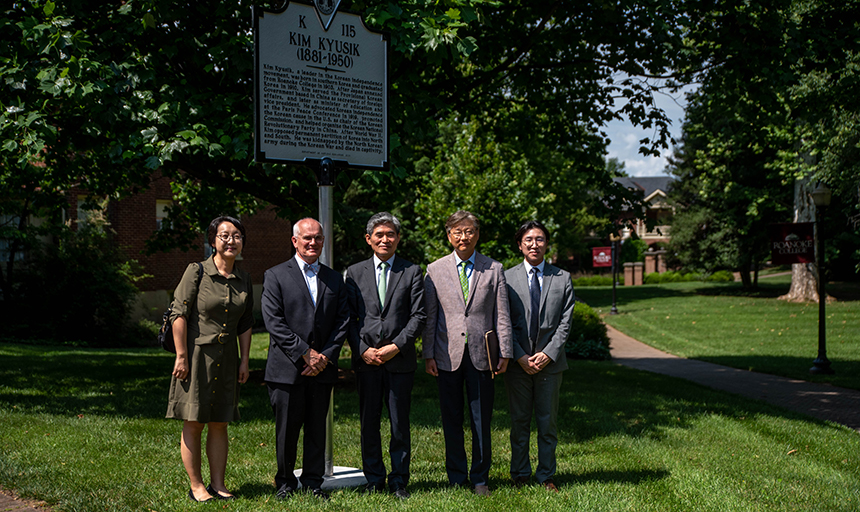 Five people stand in front of Kim Kyusik historic marker.