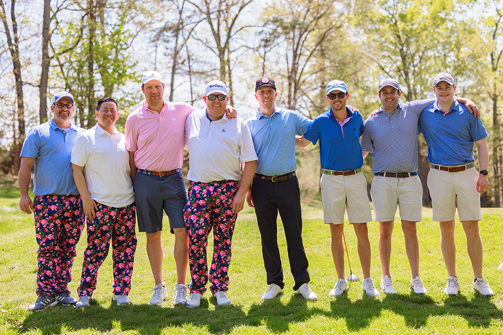 Men pose for picture on golf course
