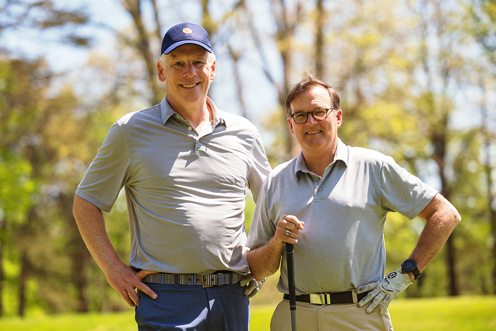 Two men pose for photo on golf course
