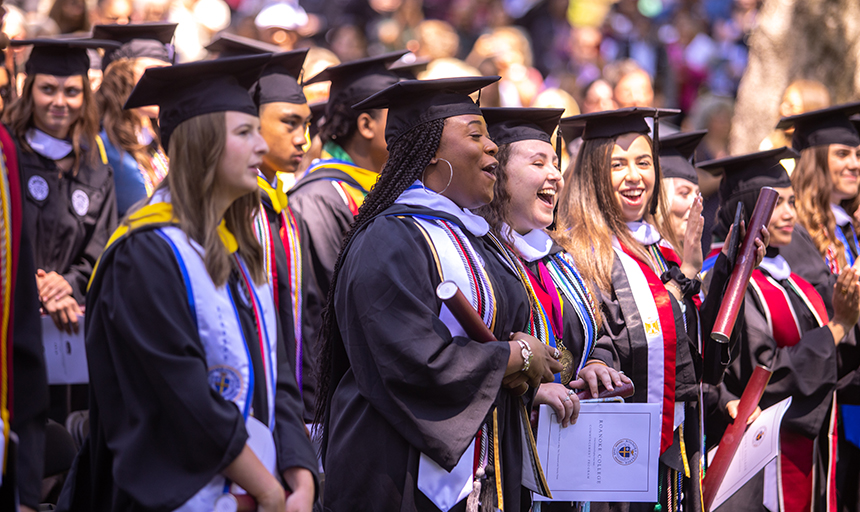 Graduates celebrate as confetti flies through the air.