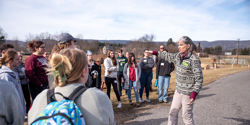 Professor talks to a group of student volunteers at the Environment Center site
