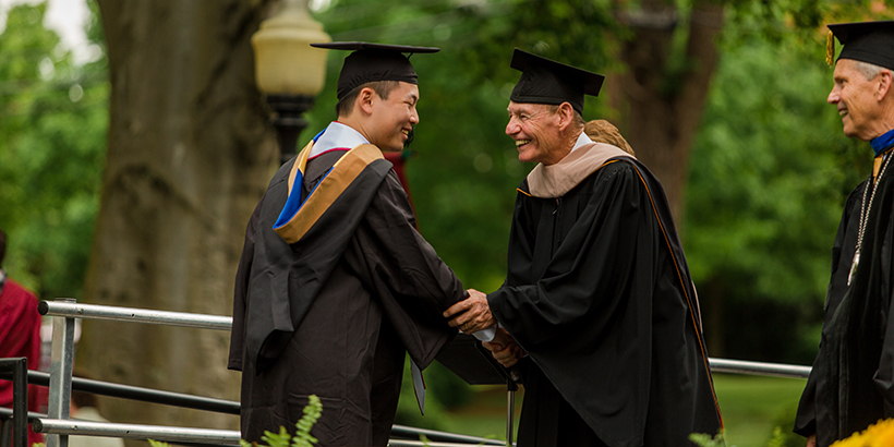 Morris Cregger shakes a graduate's hand