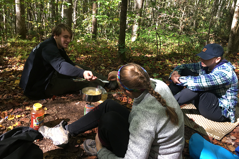 Students eating at campsite