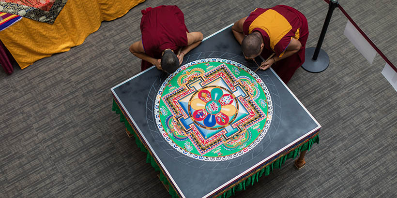 A photo from above of the Tibetan Monks working on the sand mandala, it is about three quarters of the way done