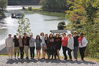 group of students posing for a photo in front of a river