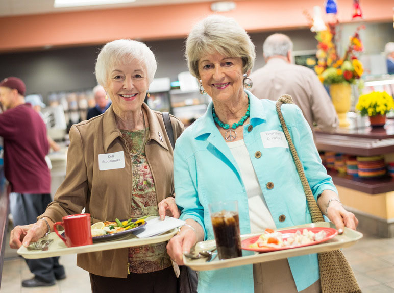 Two elderscholars eating in the Commons
