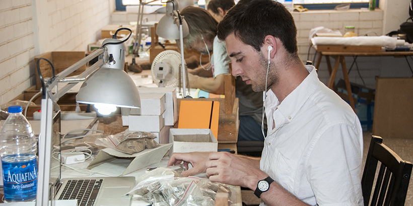 A student sifts through items at his work station 