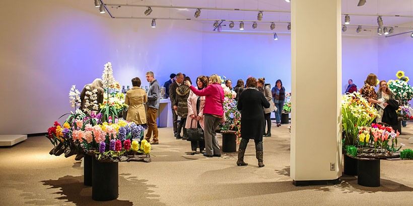 View of the Gallery Reception with flowers and visitors