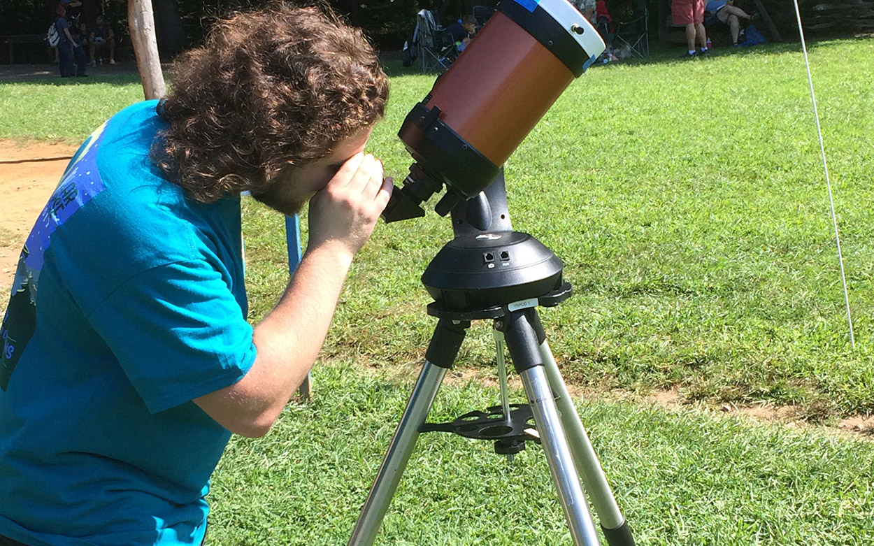 Physics student viewing the eclipse through a telescope