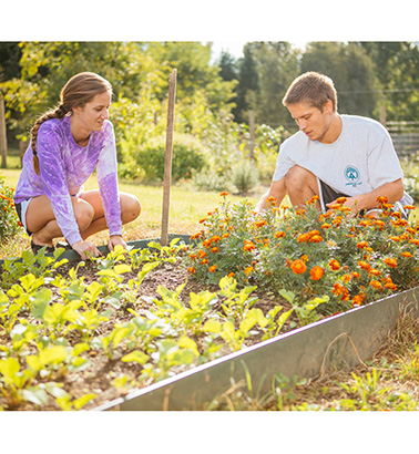 Two students planting flowers in the Student Garden