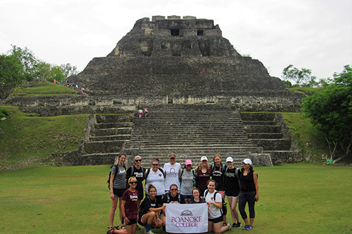 students in Belize posing with a Roanoke flag
