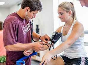 Students looking at the results on the metabolic cart as another student runs