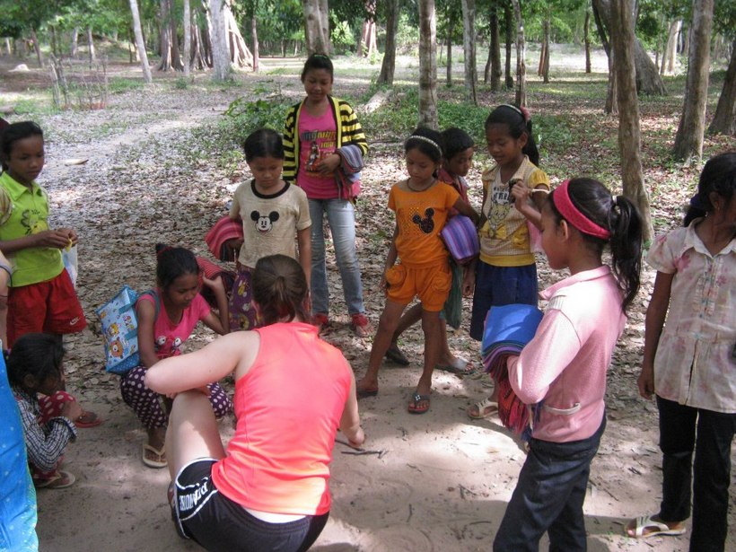 Student with a group of children in Cambodia