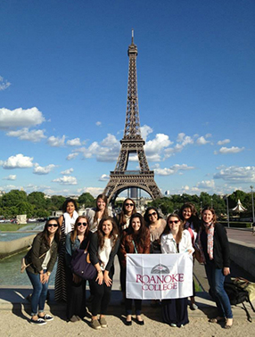 Students in front of the Eiffel Tower with a Roanoke College banner