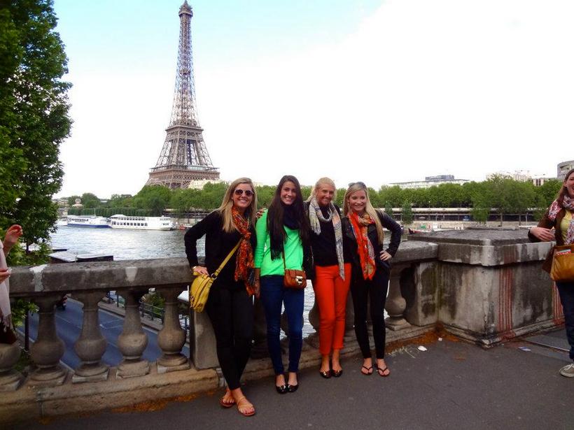 Photo of students on a bridge over the river Seine with the Eiffel tower in the background
