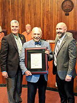 photo of Thomas Henry Row holding a framed proclamation